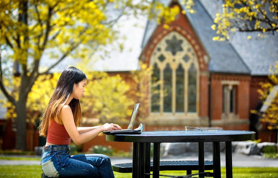 Student working in front of Sage Chapel