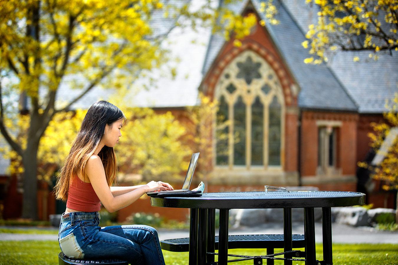 Student working in front of Sage Chapel