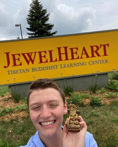 Emma Plowe smiling in front of the Jewel Heart entrance sign